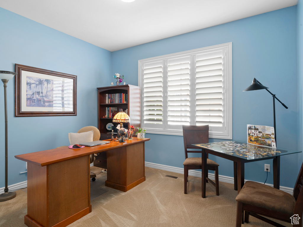 Carpeted office space featuring baseboards