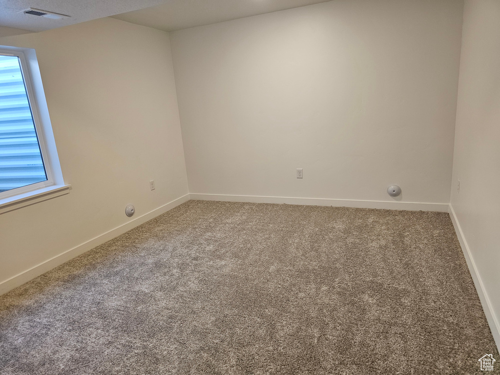 Carpeted spare room with baseboards