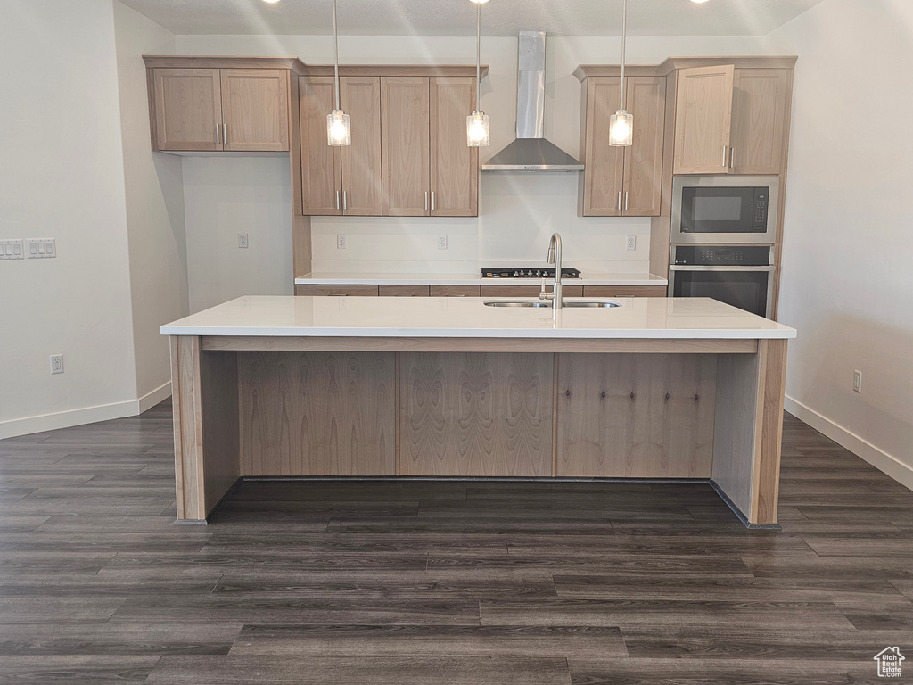 Kitchen with oven, wall chimney range hood, a sink, dark wood-type flooring, and a kitchen island with sink