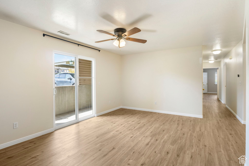 Spare room with ceiling fan, light wood-type flooring, and baseboards