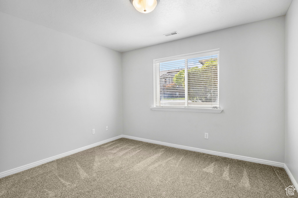 Carpeted spare room with baseboards