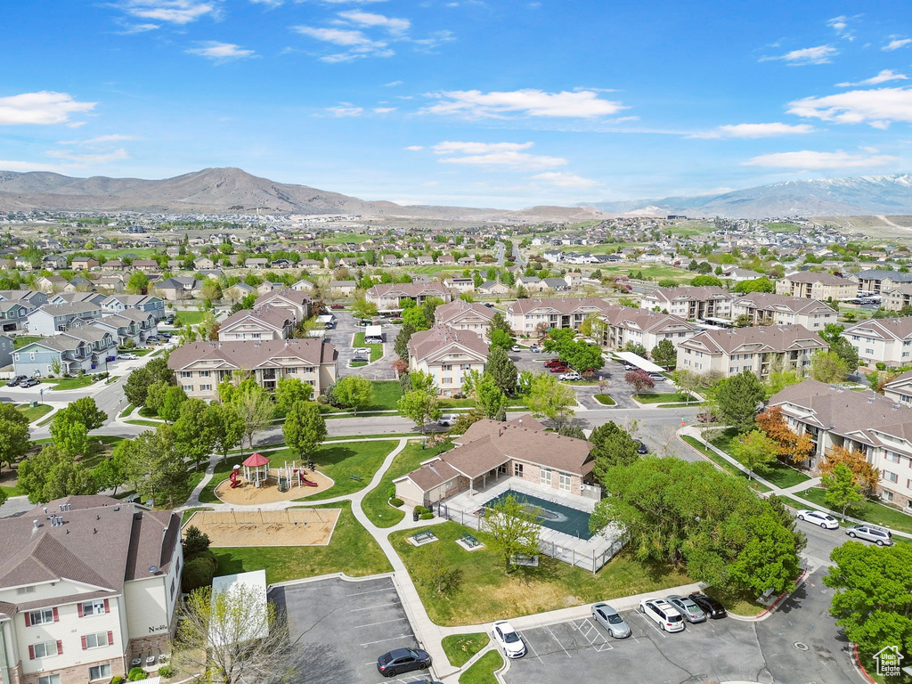Aerial view of property and surrounding area with nearby suburban area and mountains