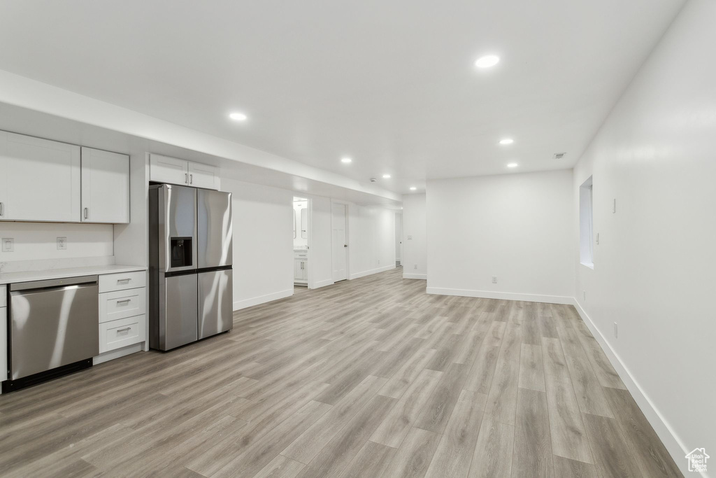 Kitchen featuring stainless steel appliances, recessed lighting, light wood finished floors, light countertops, and baseboards