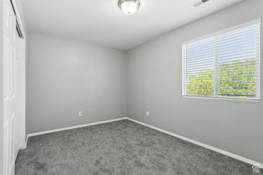 Spare room featuring carpet floors and baseboards