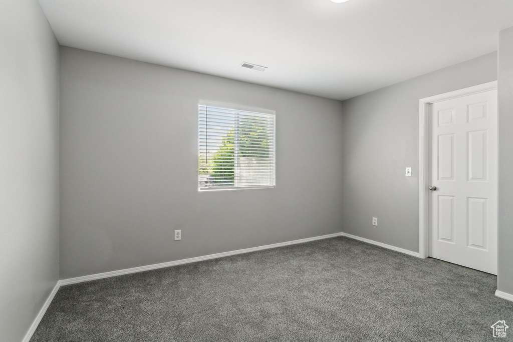 Spare room featuring carpet floors and baseboards