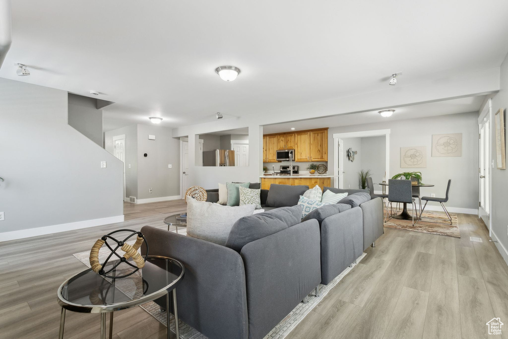 Living area featuring baseboards and light wood-type flooring