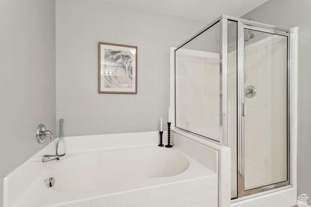 Bathroom with a shower stall and a bath
