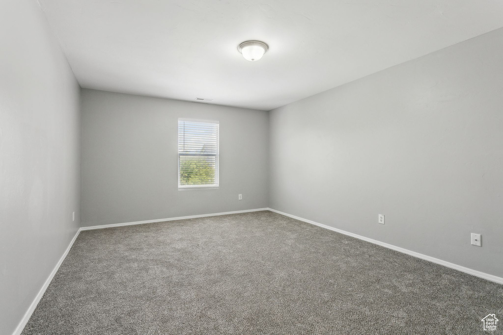 Unfurnished room featuring carpet floors and baseboards