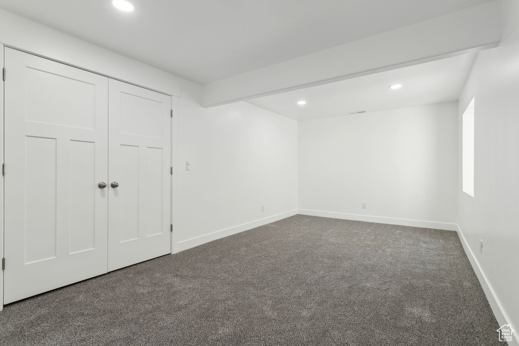 Unfurnished bedroom featuring dark colored carpet, recessed lighting, baseboards, and a closet