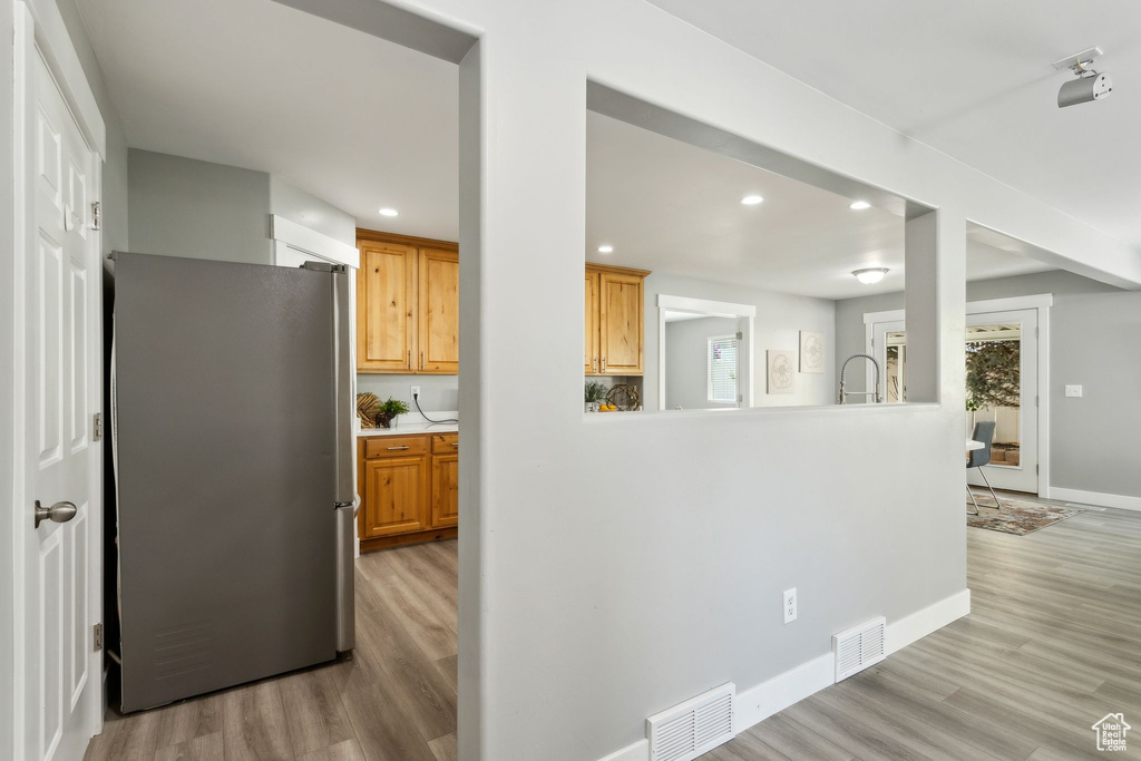 Kitchen featuring freestanding refrigerator, light wood-style flooring, recessed lighting, baseboards, and light countertops