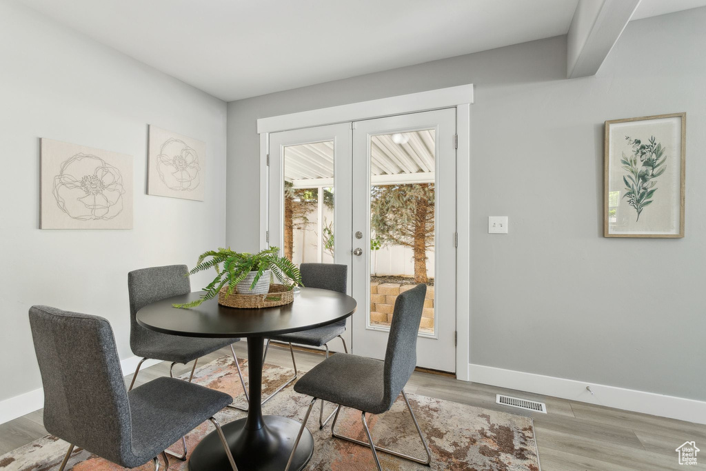 Dining space featuring baseboards, wood finished floors, and french doors