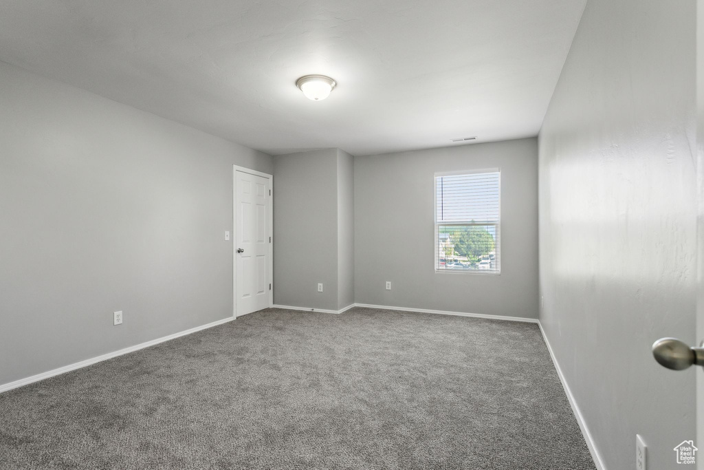 Carpeted empty room featuring baseboards