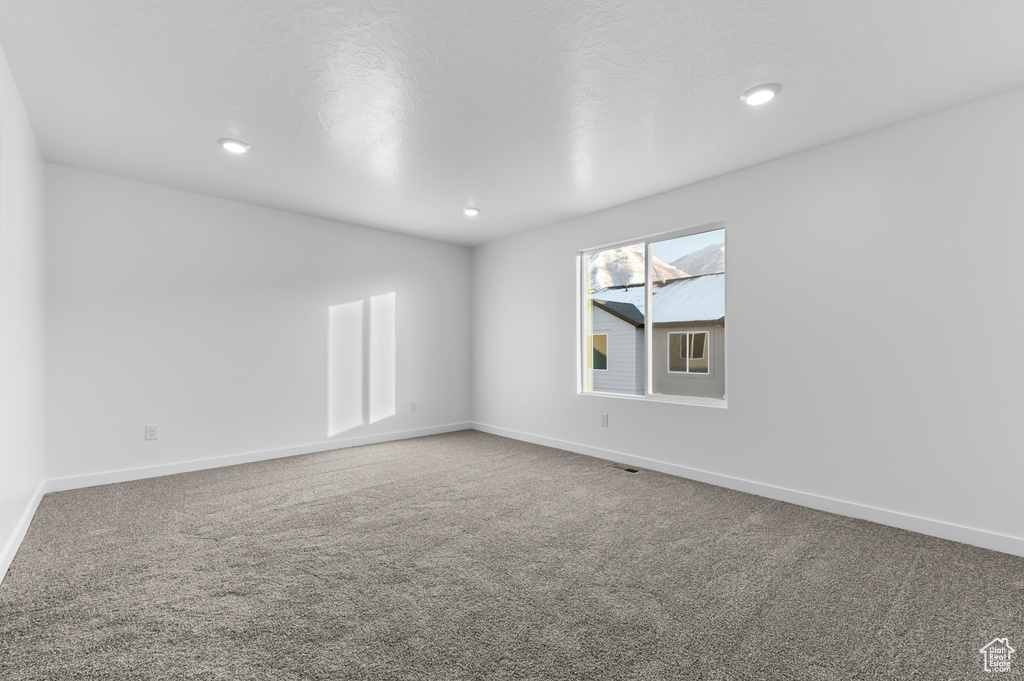 Unfurnished room featuring carpet flooring, baseboards, and recessed lighting