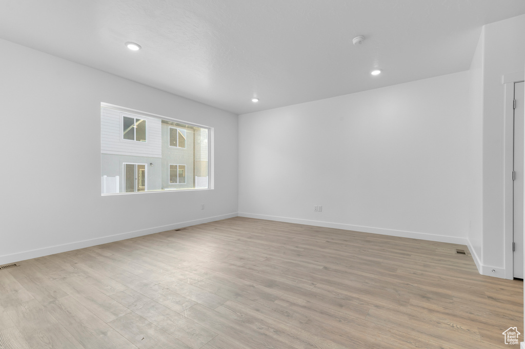 Unfurnished room with light wood-type flooring, baseboards, and recessed lighting