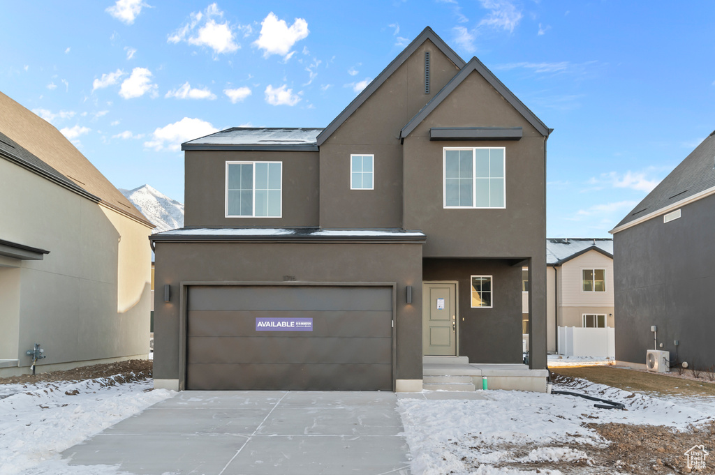 View of front facade with an attached garage, stucco siding, and concrete driveway