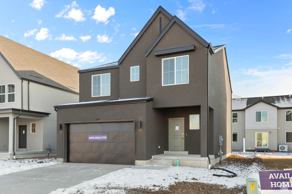 View of front of home featuring stucco siding, driveway, and an attached garage