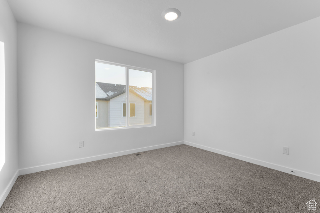 Carpeted empty room featuring baseboards