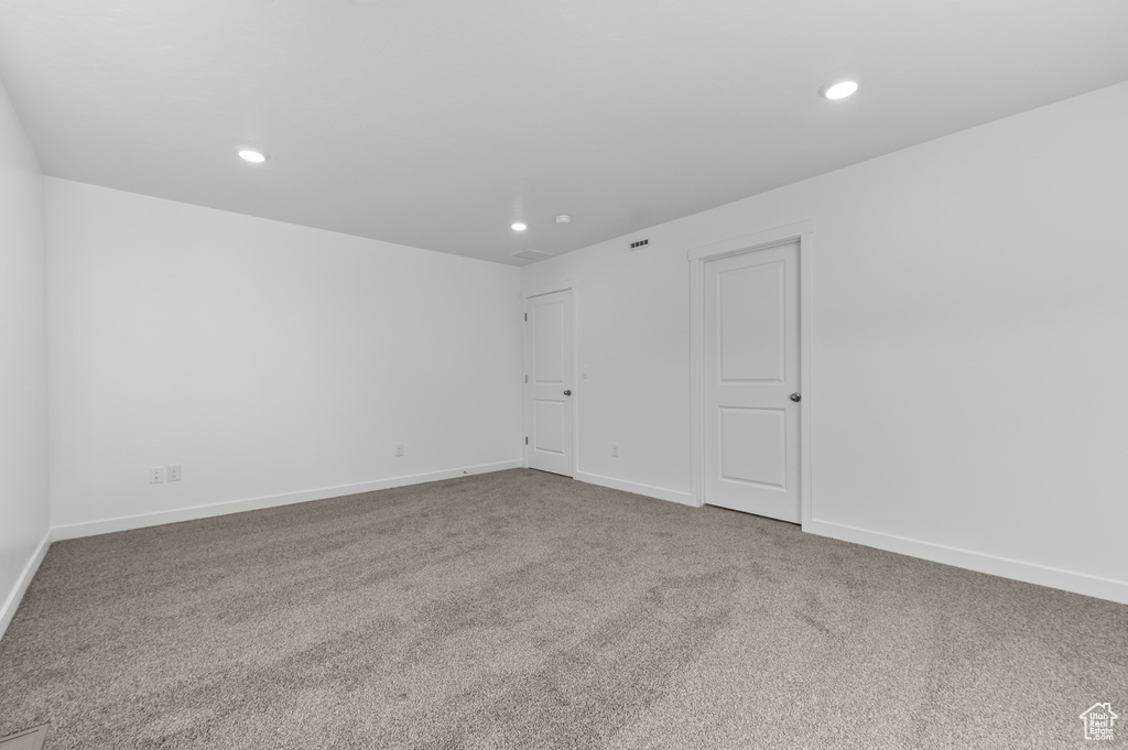Carpeted empty room featuring recessed lighting and baseboards