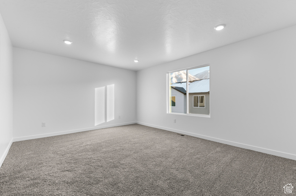 Empty room with carpet, baseboards, and recessed lighting