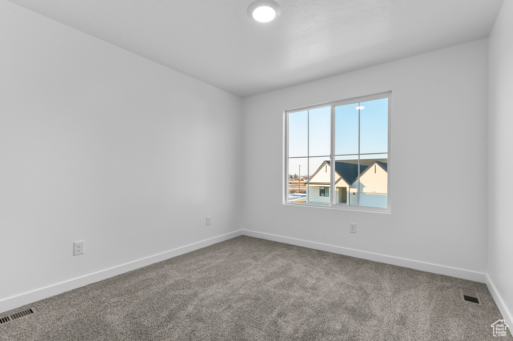 Spare room featuring carpet floors and baseboards