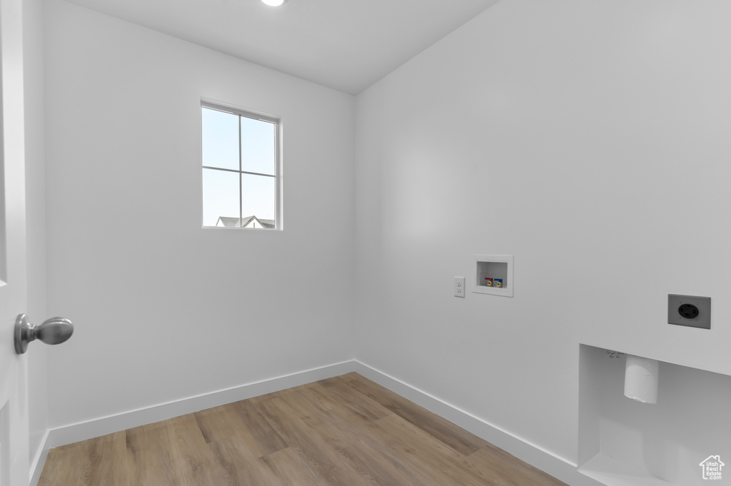 Laundry area featuring electric dryer hookup, washer hookup, baseboards, and wood finished floors