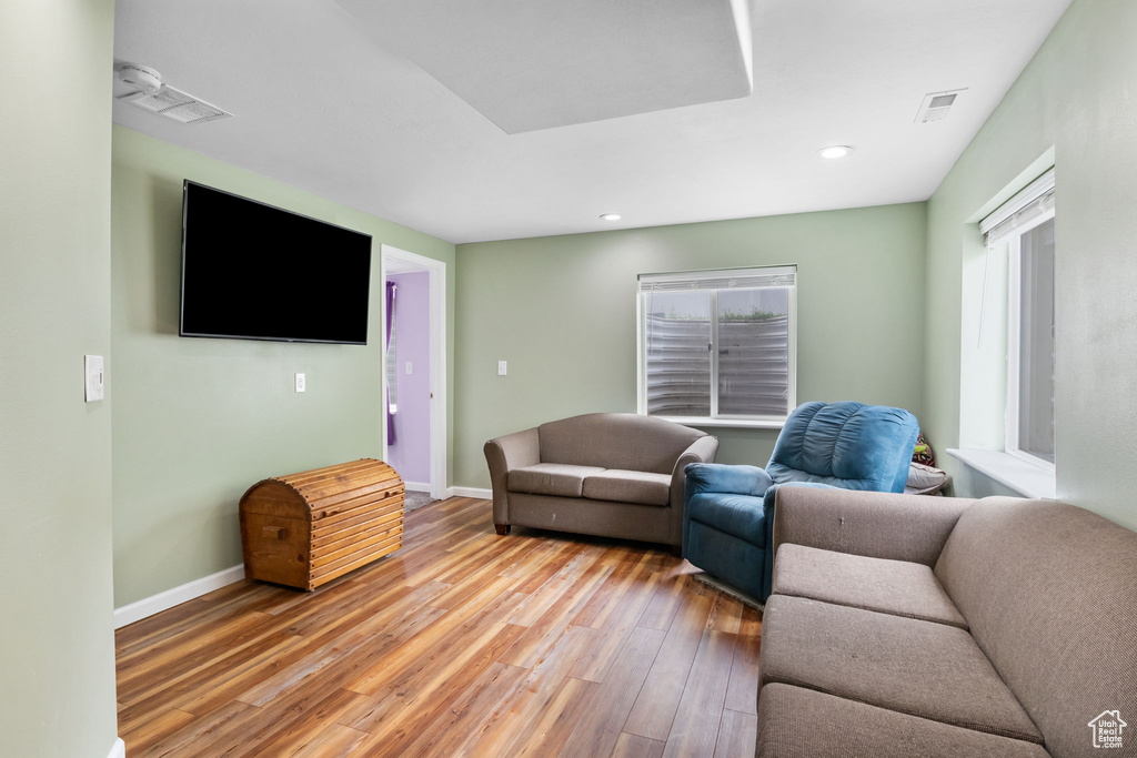 Living room with light wood-type flooring, baseboards, and recessed lighting