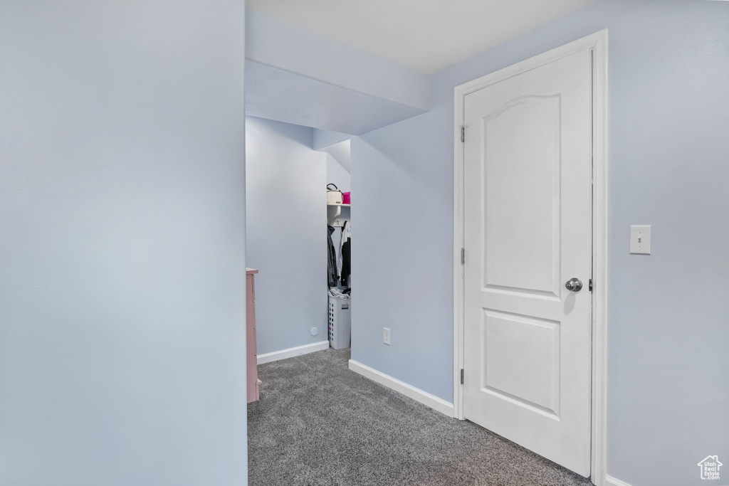 Corridor featuring carpet flooring and baseboards