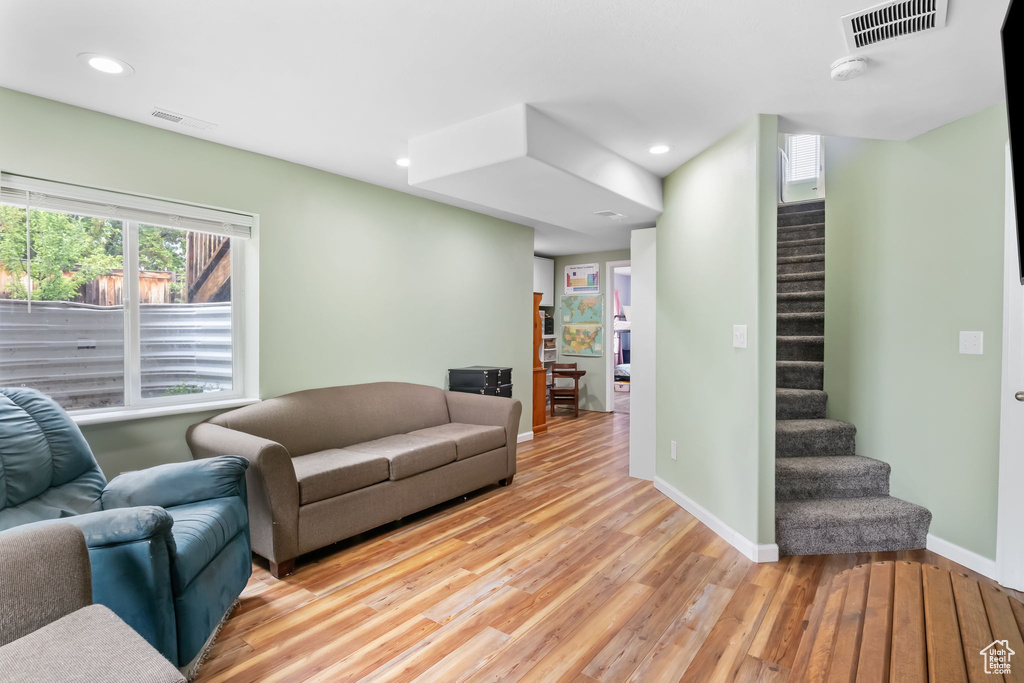 Living area with light wood-type flooring, stairs, baseboards, and recessed lighting