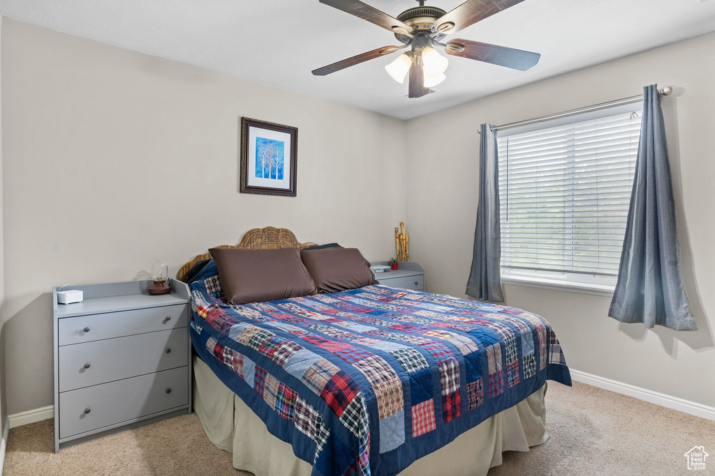 Bedroom featuring carpet floors, baseboards, and a ceiling fan
