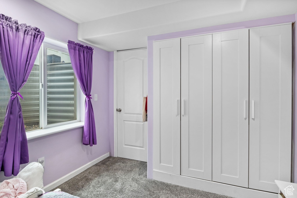 Carpeted bedroom featuring baseboards and a closet