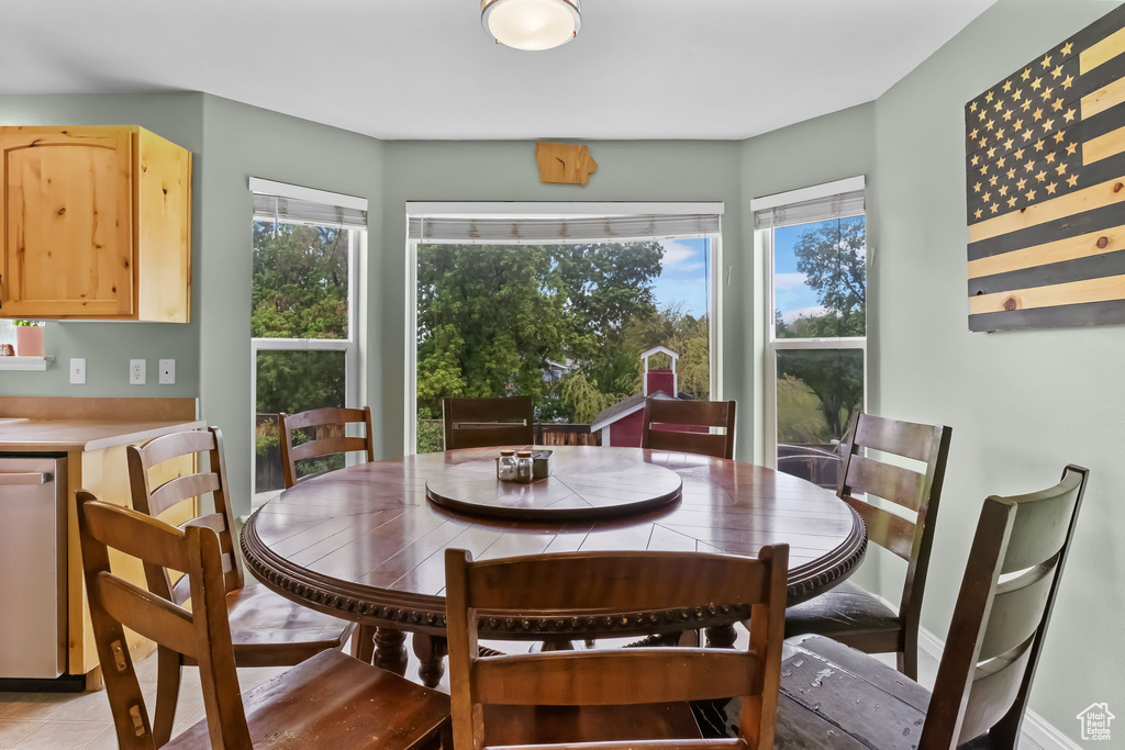 Dining space with light tile patterned flooring and baseboards