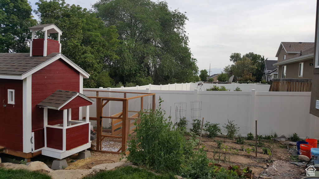 View of yard with fence, exterior structure, and an outbuilding