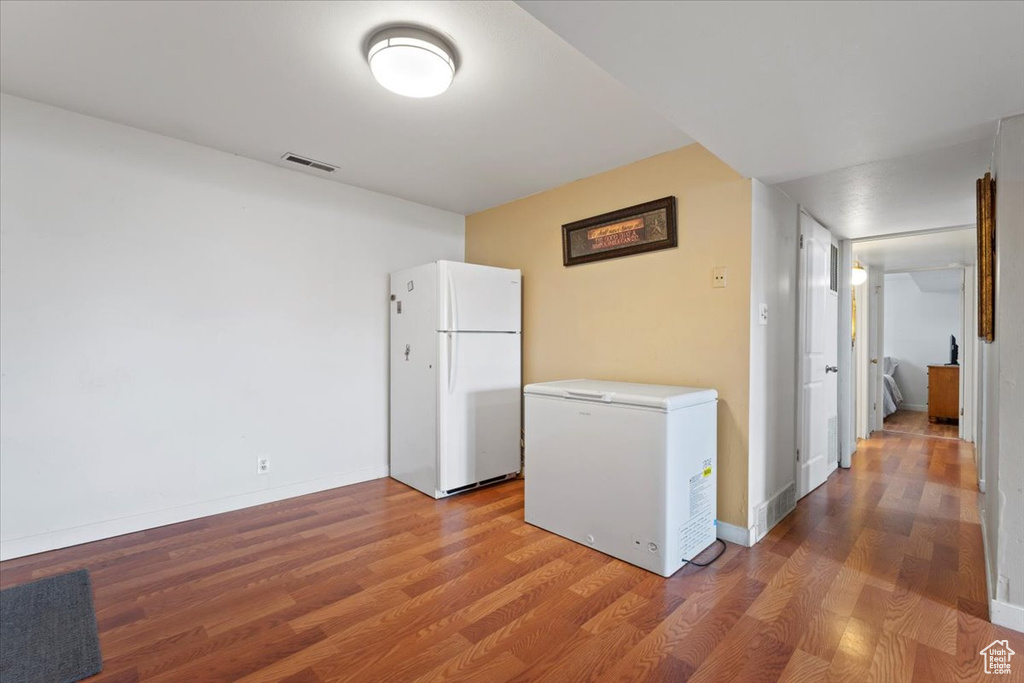 Kitchen featuring freestanding refrigerator, fridge, wood finished floors, baseboards, and light countertops