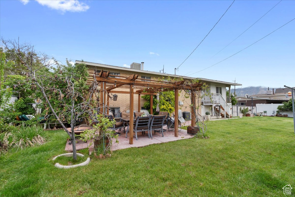 Back of property with a pergola, a patio, and stairs
