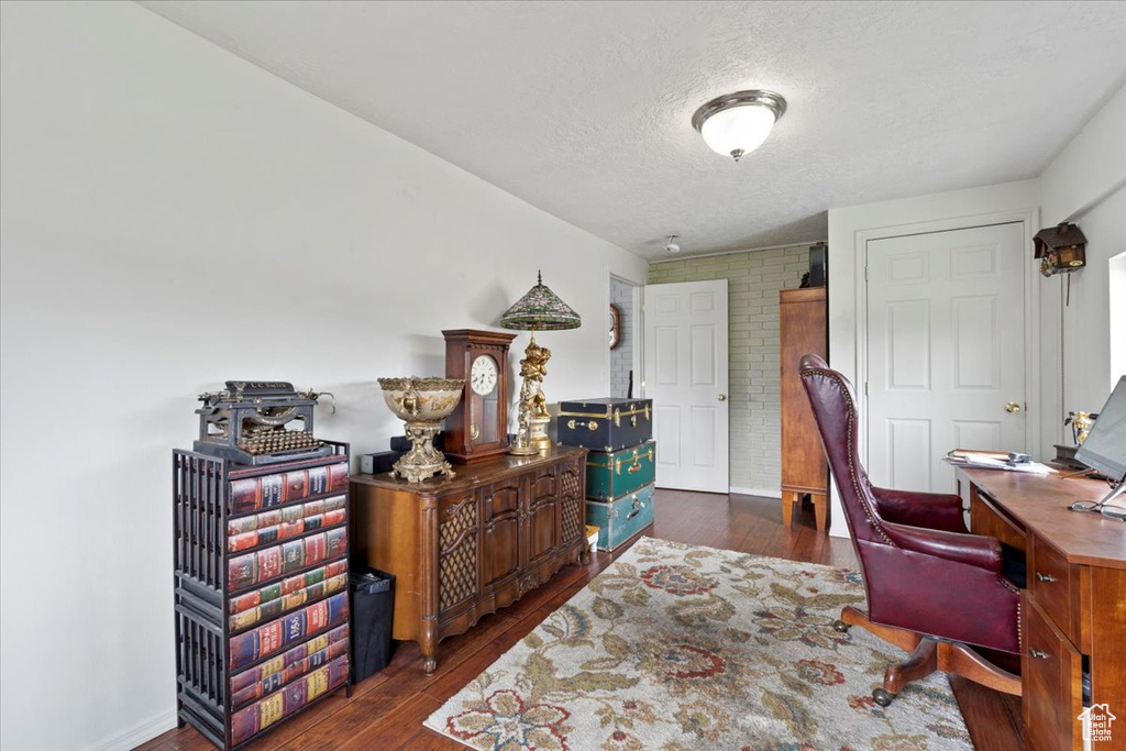 Office area with dark wood-style flooring and a textured ceiling