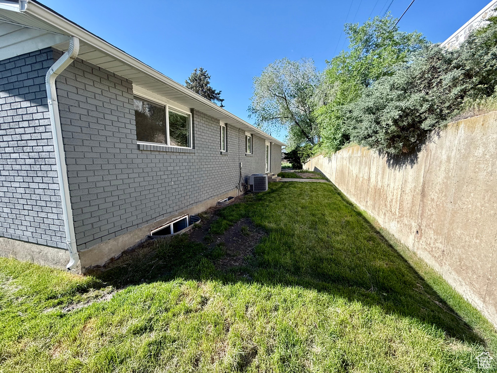 View of property exterior with central AC unit and brick siding