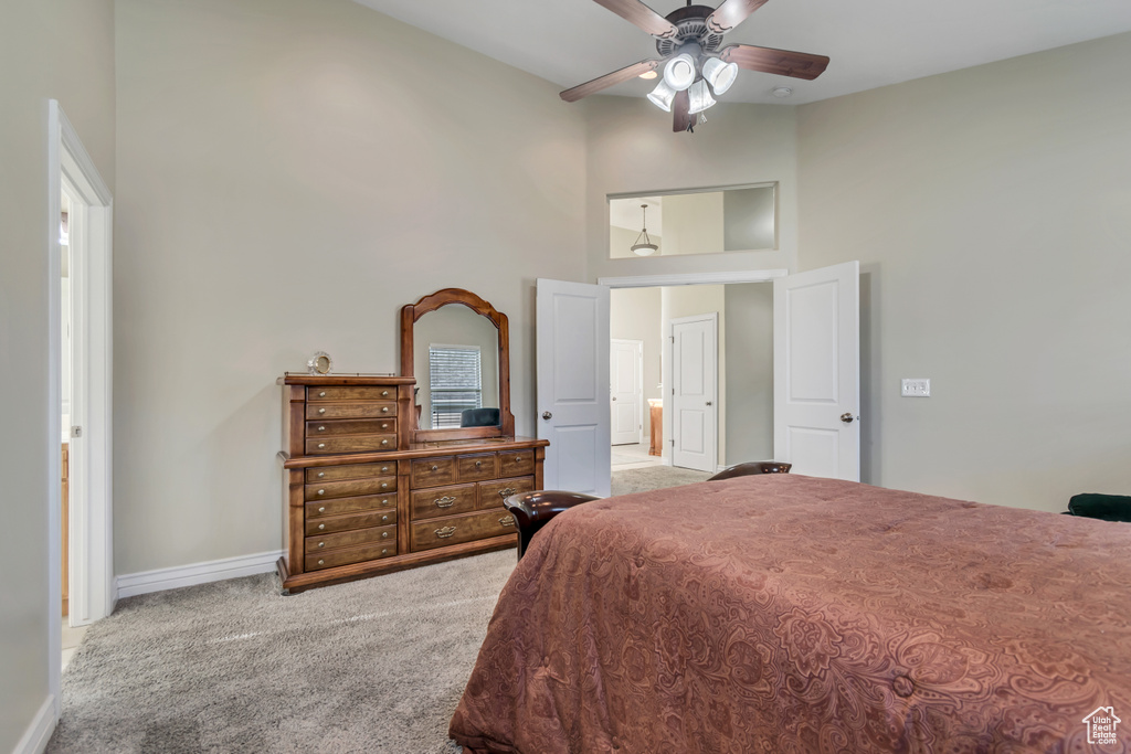 Bedroom featuring carpet flooring, baseboards, a towering ceiling, and ceiling fan