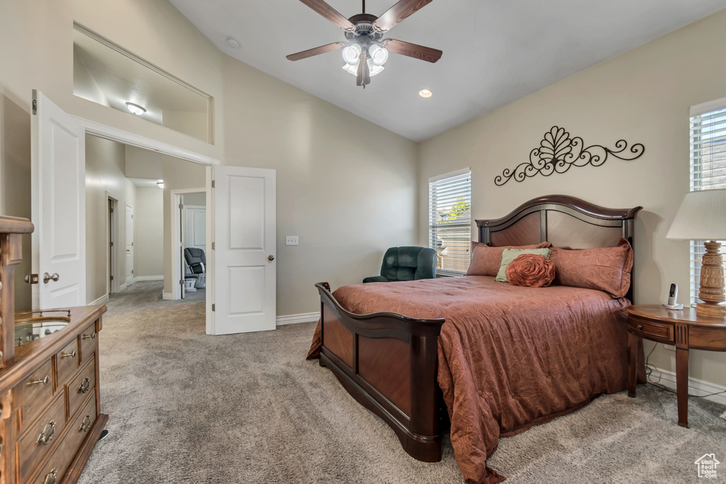 Carpeted bedroom with baseboards, high vaulted ceiling, and a ceiling fan