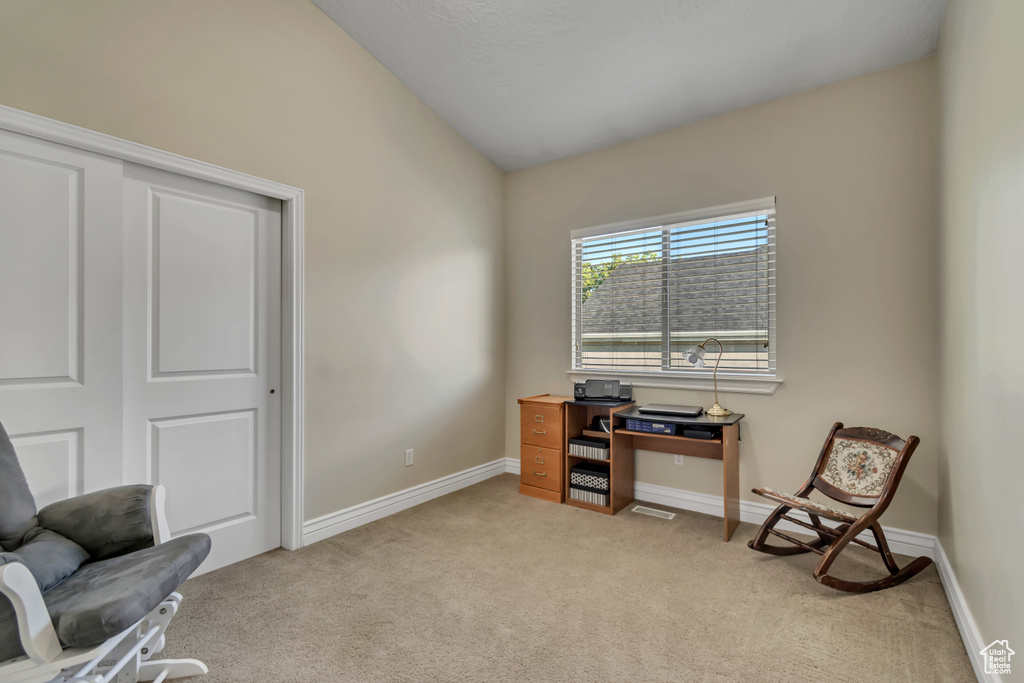 Sitting room with light carpet, lofted ceiling, and baseboards