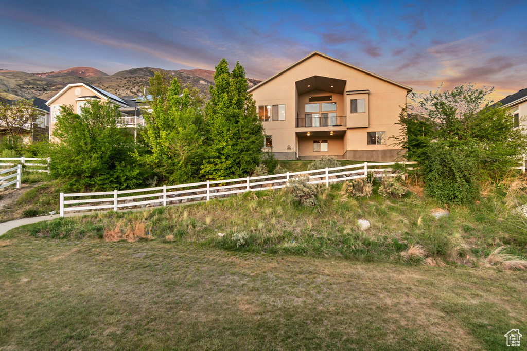 Fenced yard featuring a balcony and a mountain view