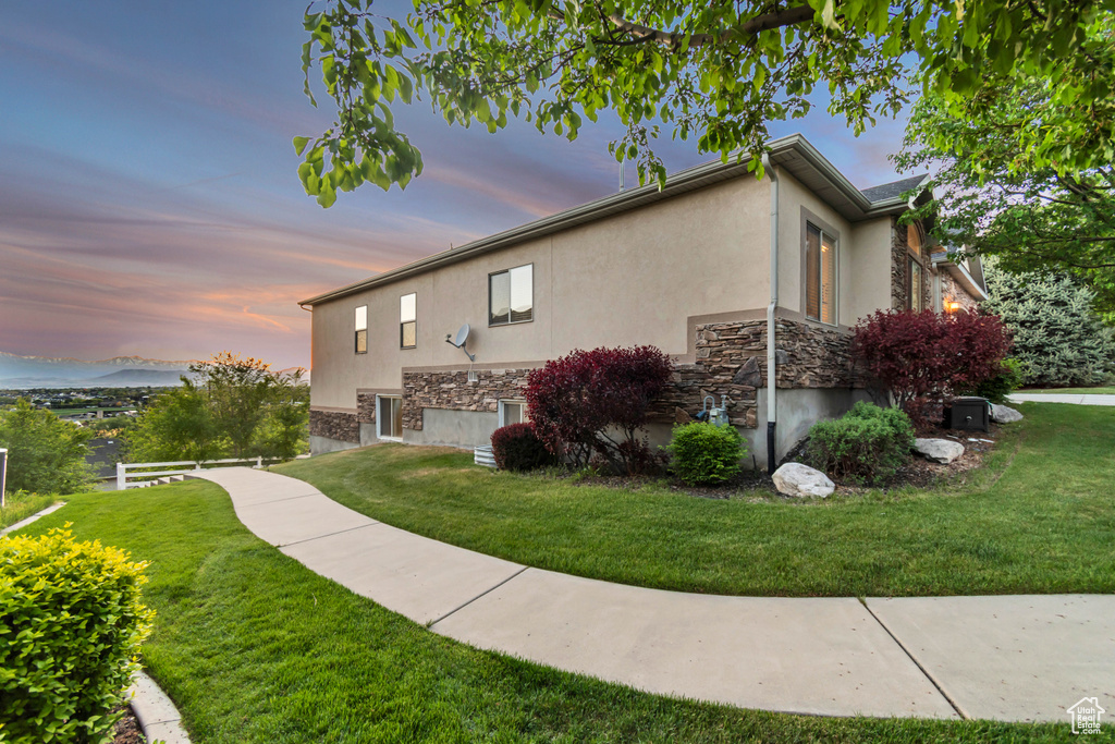 Property exterior at dusk with stucco siding and stone siding