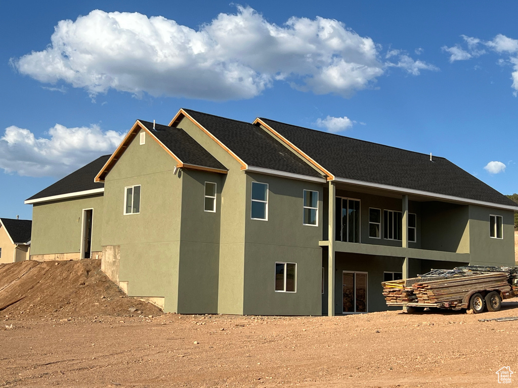 Rear view of house with stucco siding and a balcony