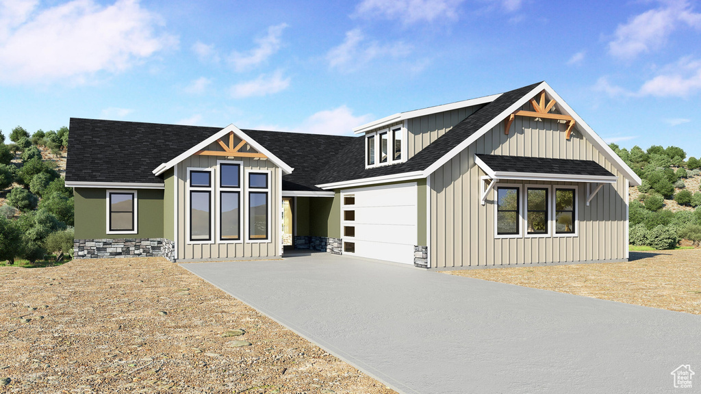 View of front of home featuring a shingled roof, concrete driveway, and board and batten siding