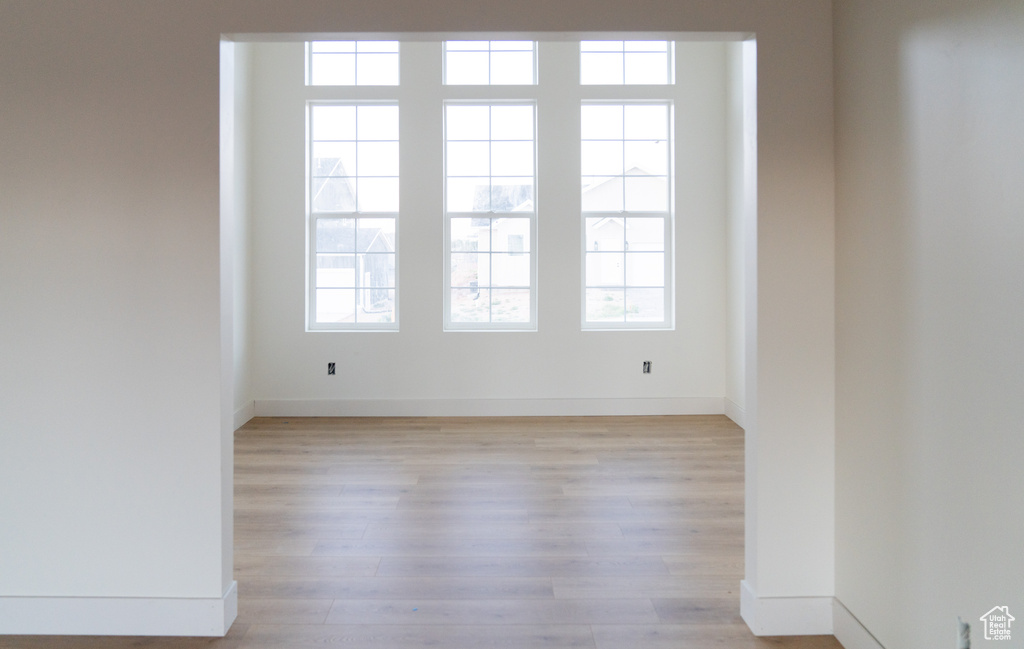 Unfurnished room with light wood-style flooring and baseboards