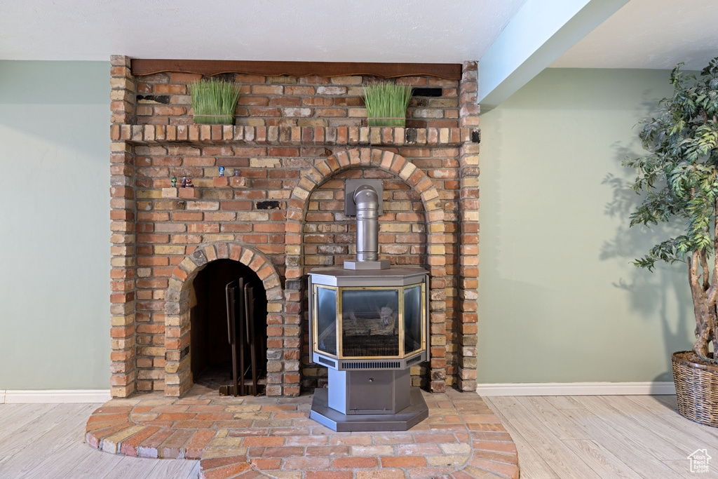Detailed view of a wood stove, baseboards, and wood finished floors