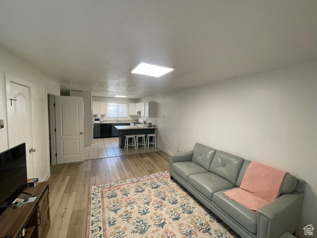 Living room featuring light wood-style floors and baseboards