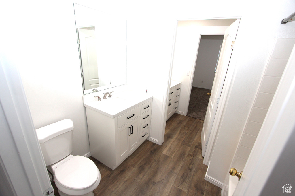 Bathroom featuring wood finished floors, vanity, and toilet