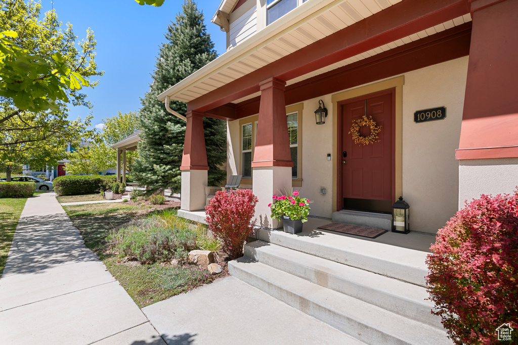 Entrance to property featuring stucco siding and a porch