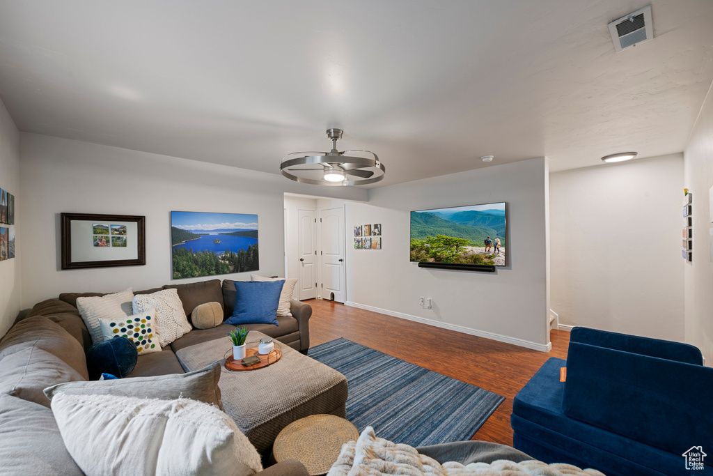 Living area featuring wood finished floors, visible vents, baseboards, and ceiling fan