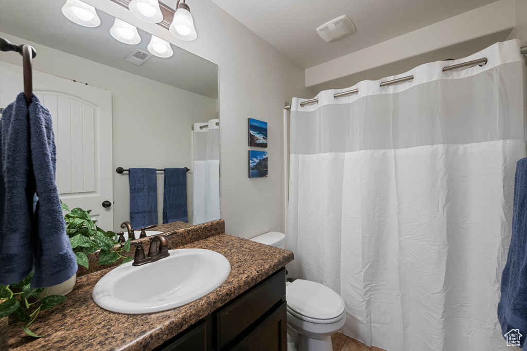 Bathroom featuring toilet, tile patterned flooring, vanity, and visible vents